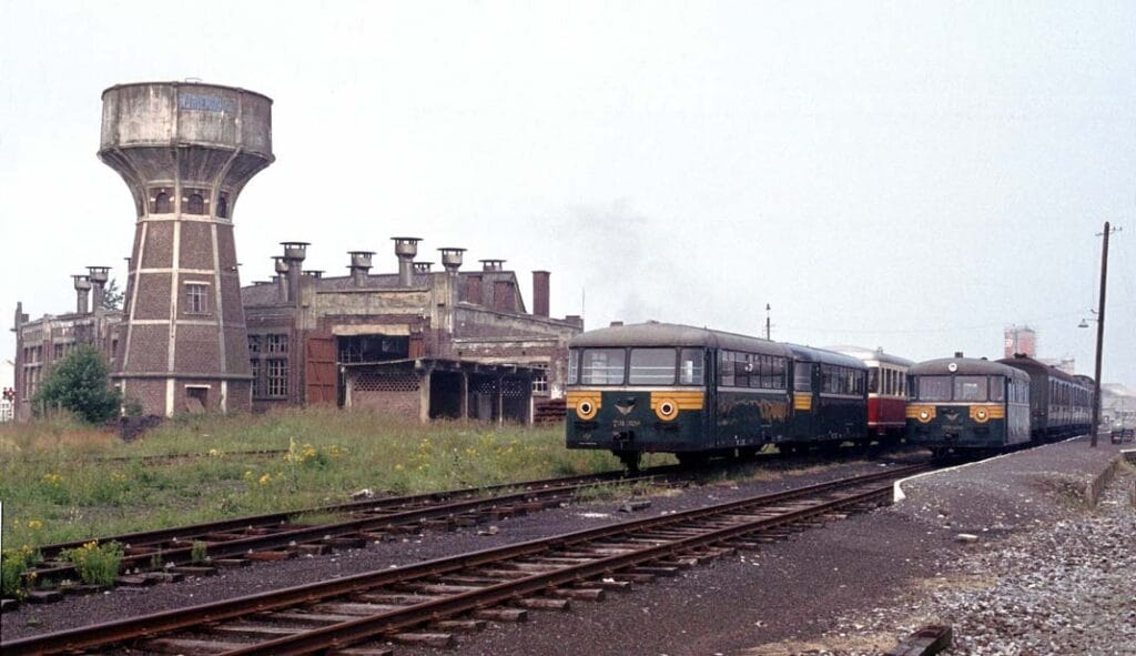 Deze foto toont railbussen van de Drie Valleien Stoomtrein naast het depot voor de lijn naar Treignes (oostelijk van het NMBS-station) op 9 juli 1983. Foto: Roelof Hamoen.